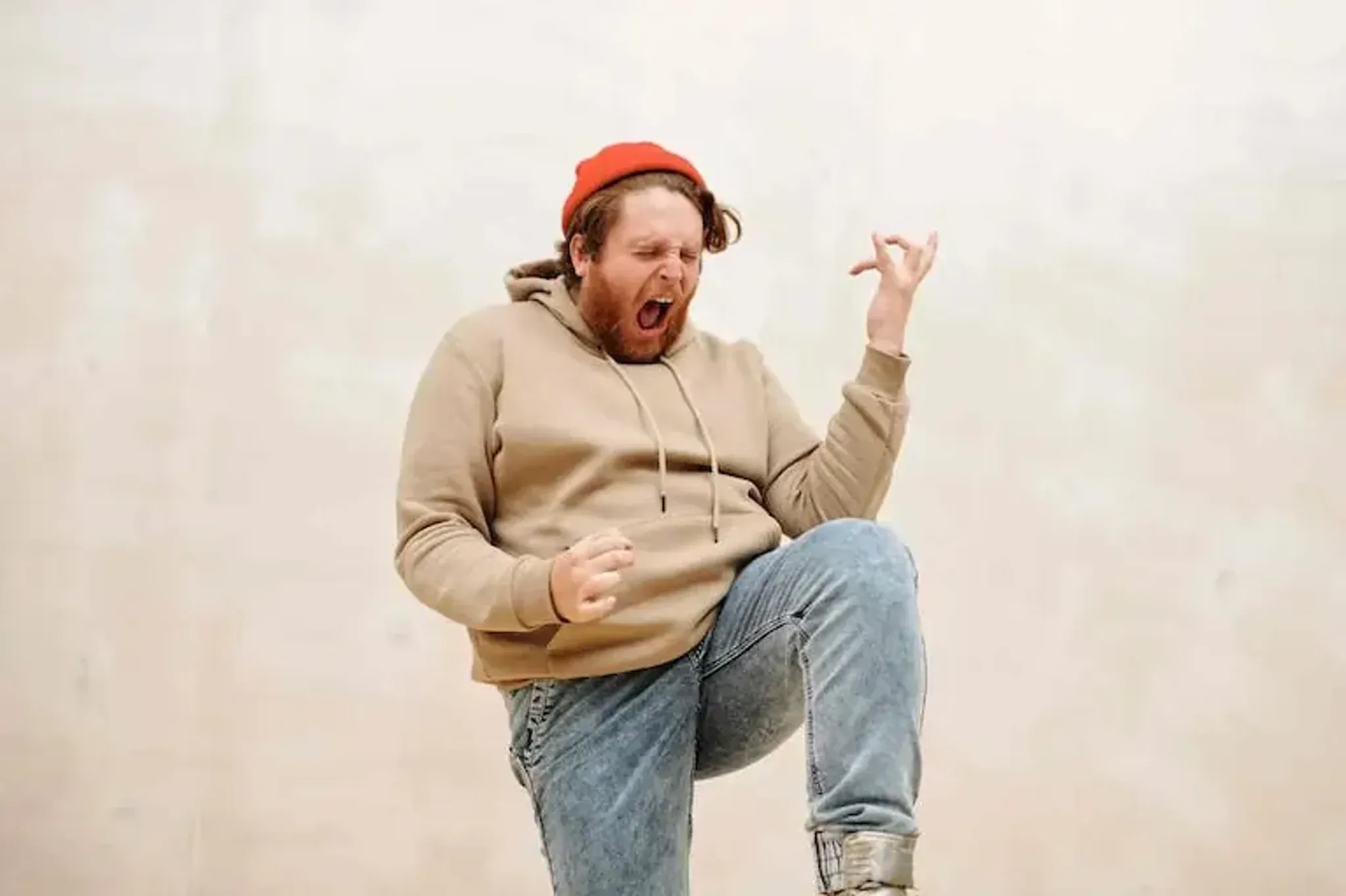 Excited man celebrating enthusiastically by playing air guitar.